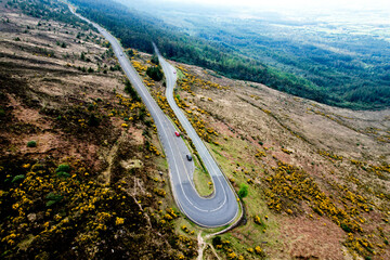  Aerial view of The Vee Pass winding through the Knockmealdown Mountains, showcasing stunning Irish landscape, vibrant greenery, and dramatic elevation in County Tipperary, Ireland.
