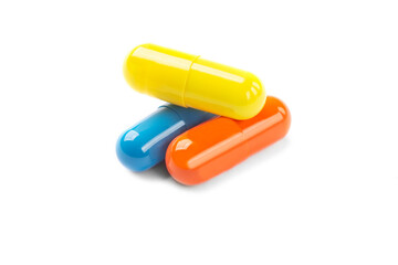 medical pills capsules yellow blue and orange on white background