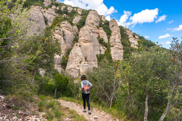Tourist walking on a path in montserrat mountains near barcelona, catalonia, spain