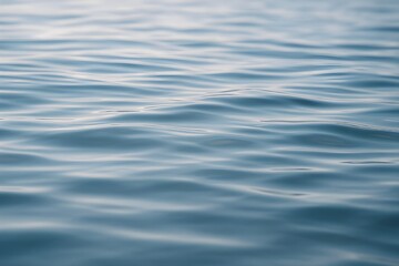 Peaceful water texture with blue waves. Blue water surface with smooth soft ripples. Minimalist water background with smooth waves. Background suitable for a variety of creative and commercial uses.