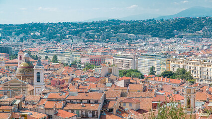 Fototapeta premium Bright sun lights red roofs of the old city timelapse. Aerial view from Shatto's hill. Nice, France