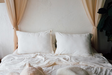 Cozy bed with white pillows and soft blankets in a serene bedroom setting