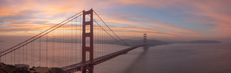 Golden Gate Bridge detail seen at sunrise with dramatic warm tones lighting fog and support cables, January 4, 2019, San Francisco, CA, USA