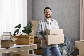 Moving day. Man with cardboard boxes in his new home