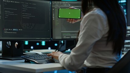 Technician using mockup mobile phone in data center, managing servers. Expert in server hub using isolated screen smartphone to ensure networks are secure and functioning properly, camera A
