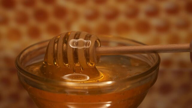 Wooden spoon filling by honey from the jar