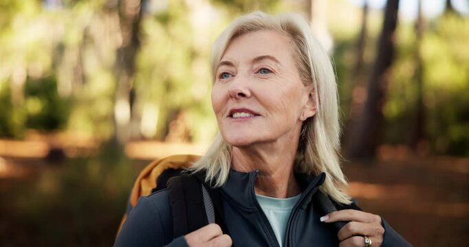 Hiking, senior woman and walking in forest for adventure, retirement hobby and cardio wellness. Mature person, thinking and journey with backpack for trekking, explore or holiday sightseeing in woods