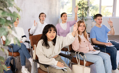 Young female asian student listening attentively to lecture in lecture hall