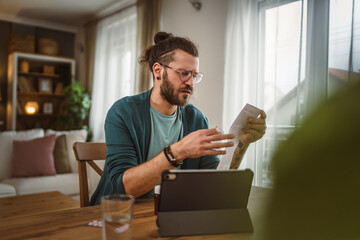 One adult man read recipe for medicament on tablet at living room at home