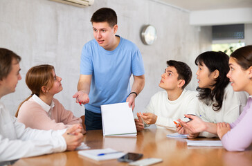 Obraz premium Young male professor explaining subject to group of students