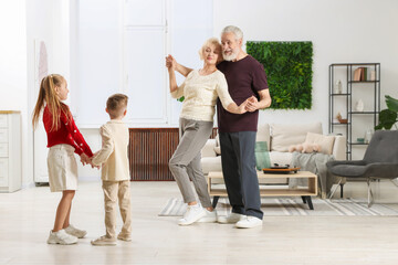 Naklejka premium Grandparents and their grandkids having fun together at home