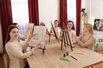 Fototapeta premium Group of women learning to draw at wooden table in class