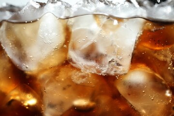 Refreshing cola with ice and bubbles, macro view