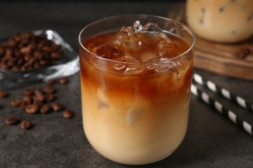 Tasty iced coffee and beans on grey table, closeup