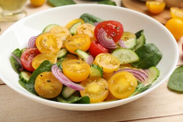 Fresh salad with yellow tomatoes on wooden table, closeup