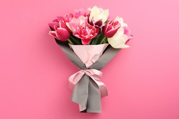Bouquet of beautiful tulips on pink background, top view