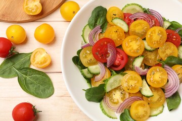 Fresh salad with yellow tomatoes served on wooden table, flat lay