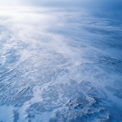 Aerial view of a snowy, windy landscape.