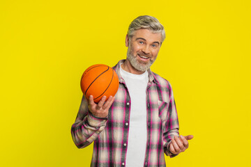 Mature man skillfully bounces basketball on hands, play game, showcasing confident flair, smooth...