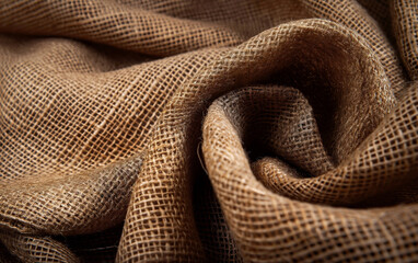 Fototapeta premium Closeup of wrinkled burlap fabric with warm light and deep texture