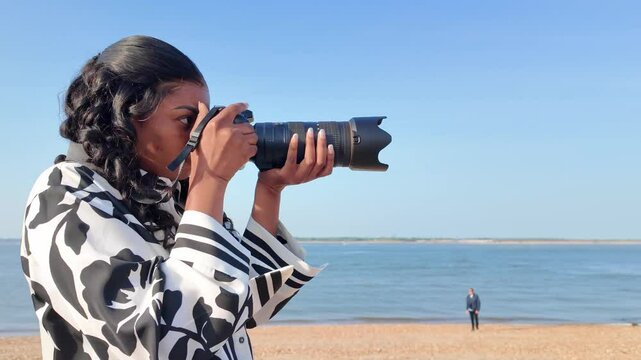 Calshot Hampshire England UK. 20.04.2025. Video. Young person holding a camera and zoom lens on holiday.