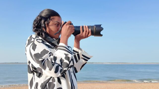 Calshot Hampshire England UK. 20.04.2025. Video. Young person holding a camera and zoom lens on holiday.