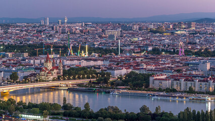 Obraz premium Aerial panoramic view over Vienna city with skyscrapers, historic buildings and a riverside promenade day to night timelapse in Austria.