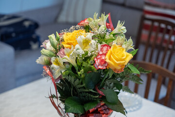 A vase of flowers sits on a table