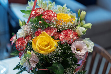 A bouquet of flowers with a pink ribbon is sitting on a table