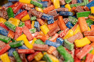 Colorful assorted candies in a close-up display during a festive market event in the afternoon sun