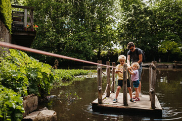 Family using a raft or floater to go over a pond outdoors
