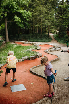 Kids playing miniature golf outdoors