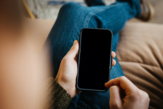 person holding a phone while sitting on a couch casual