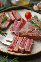 Fototapeta premium Pieces of delicious beef meat, spices and tomato on table, closeup