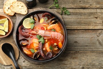 Delicious seafood soup served on wooden table, flat lay. Space for text