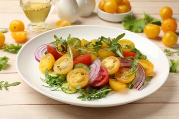 Fresh salad with yellow tomatoes on white wooden table, closeup
