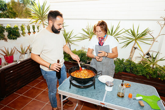 Mother and son preparing arroz con pulpo dish