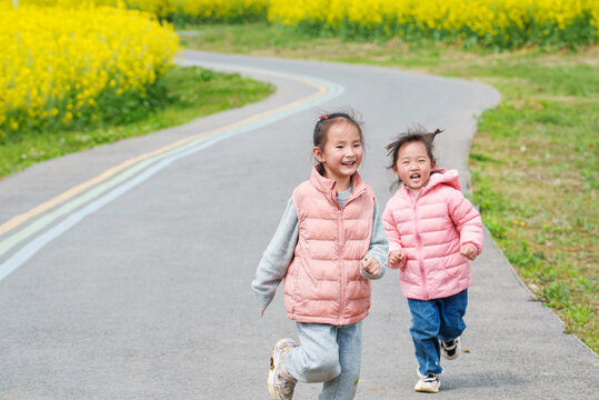 Naklejki Two lovely little asian kids running outdoor in sunny spring day