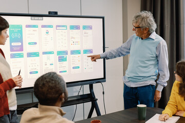 Company boss pointing for employees during presentation of app design