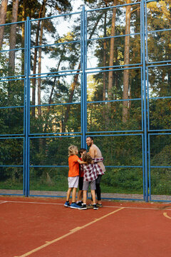 Group of kids hugging their favorite PE instructor on basketball court