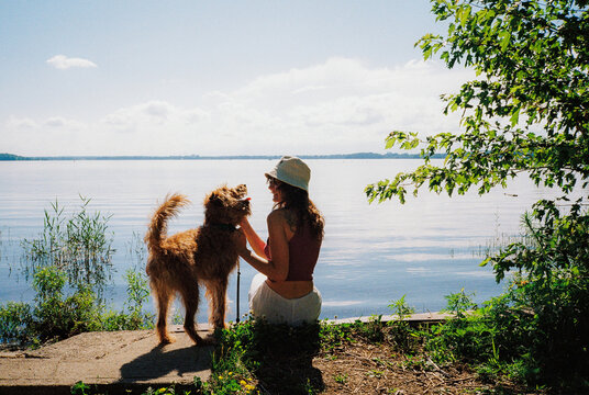 Woman with dog near the lake in summer 