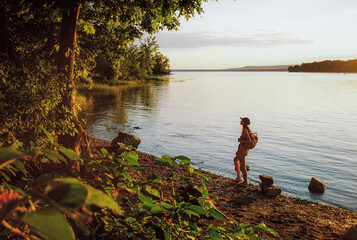 Woman looking at lake during the recharging walk in summer on weekend