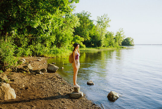 Woman looking at lake during the recharging walk in summer on weekend