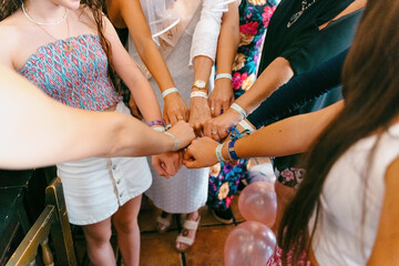 Women wearing matching bracelets at a  party. 