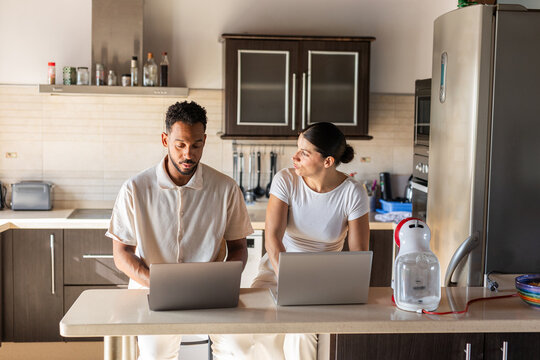 A couple working from their kitchen at home