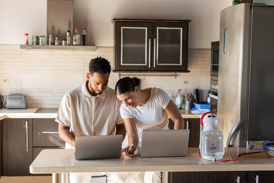 A couple working from their kitchen at home