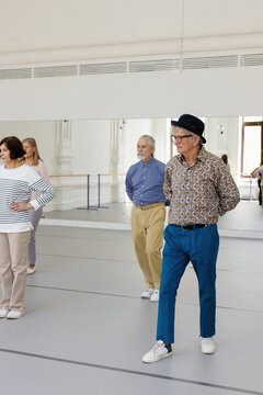 Elderly people learning basic dance steps at dance school