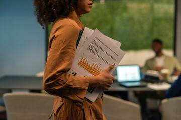 Woman with financial reports coming to meeting room