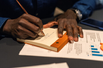 Anonymous employee writing notes in notepad