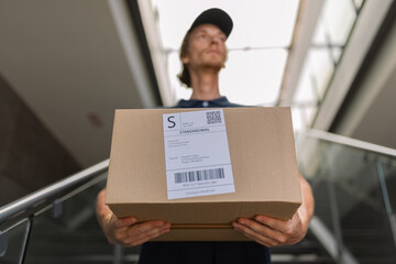 Courier holding cardboard box in hands